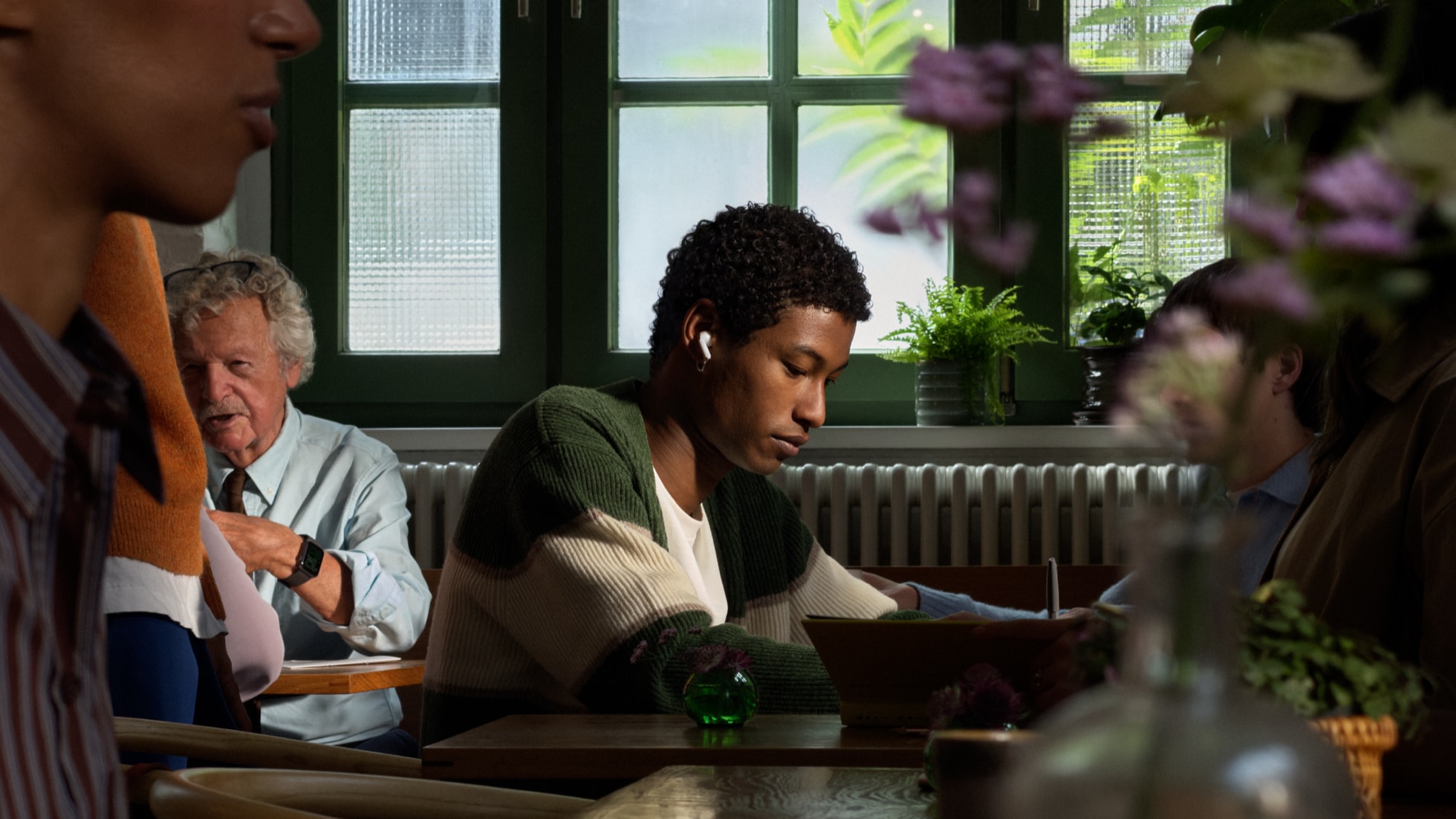 Person wearing AirPods 5 lifestyle shot from Apple Newsroom